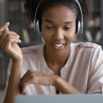 Young woman joyfully works at laptop