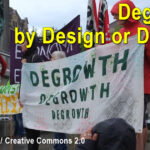 Protest crowd holds degrowth banner